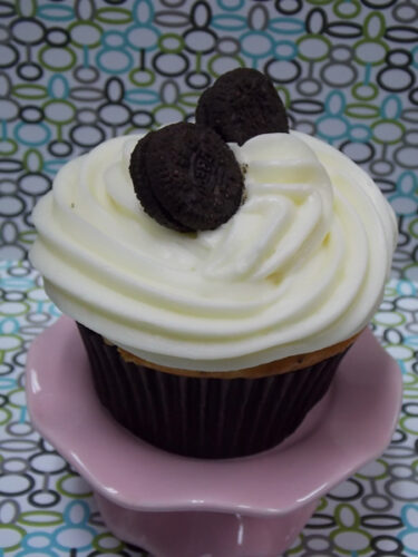 Vanilla cupcake with Oreo cookie chunks baked in and topped with white chocolate cream cheese and mini Oreo cookies